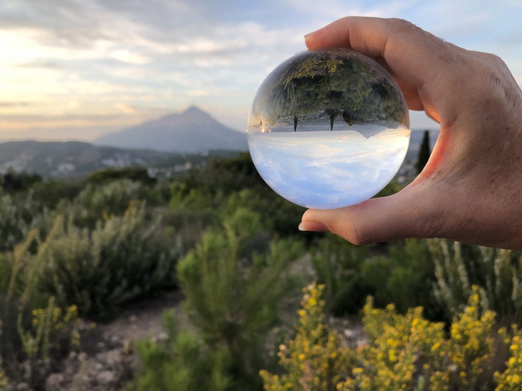 una bola que muestra un paisaje de campo y montaña